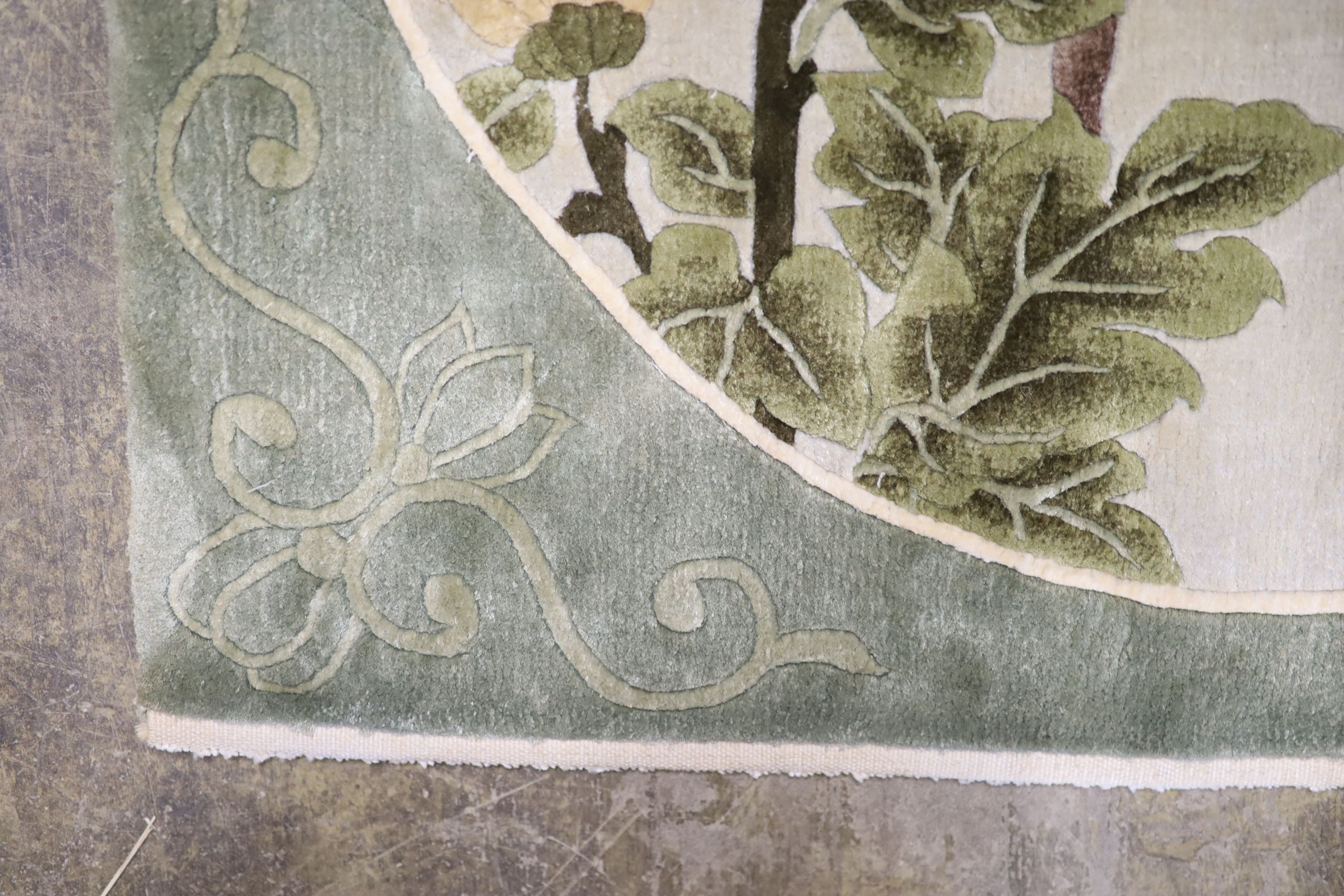 A Chinese washed and embossed panel depicting birds amongst prunus and cherries